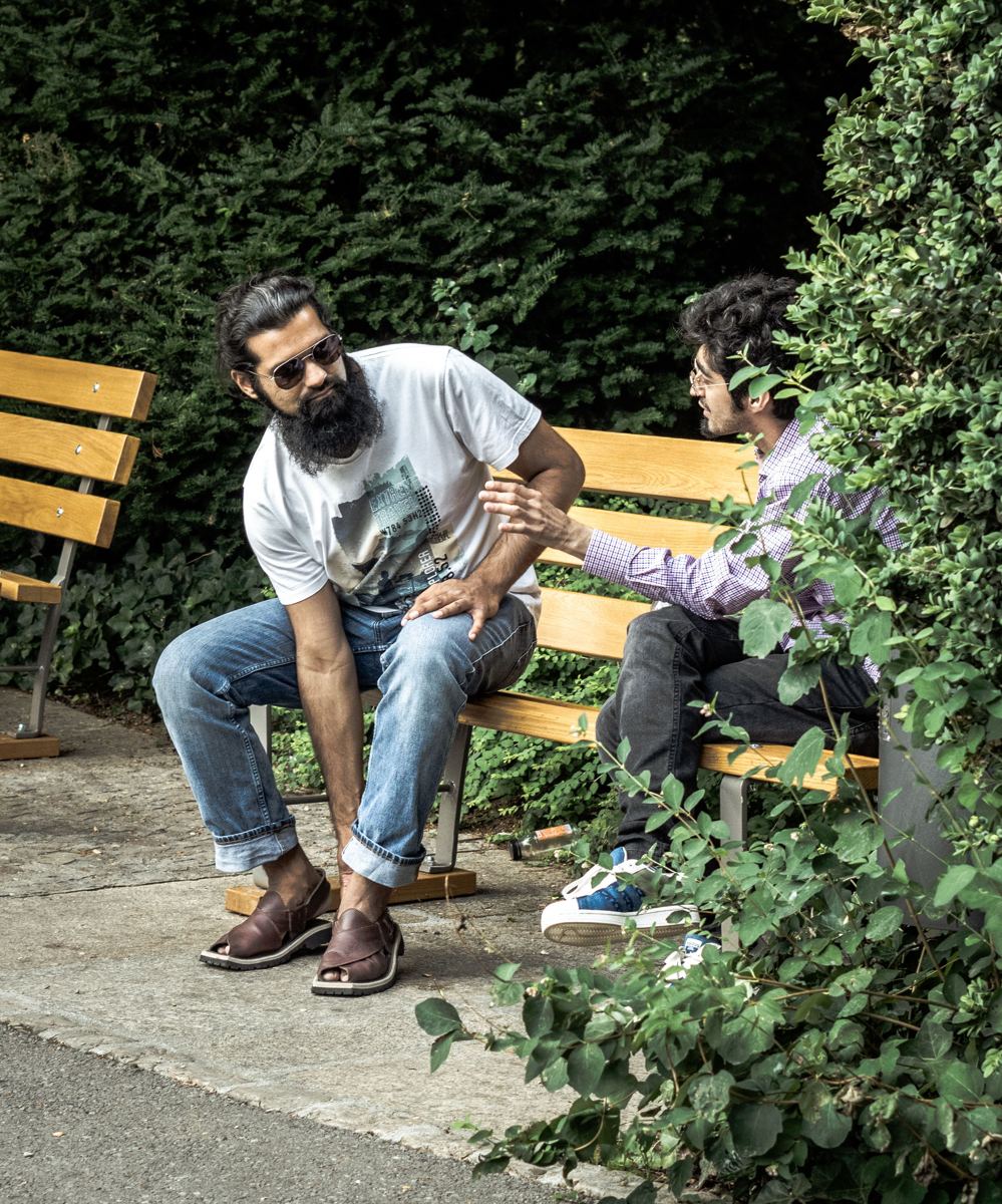 Two men talking on a park bench
