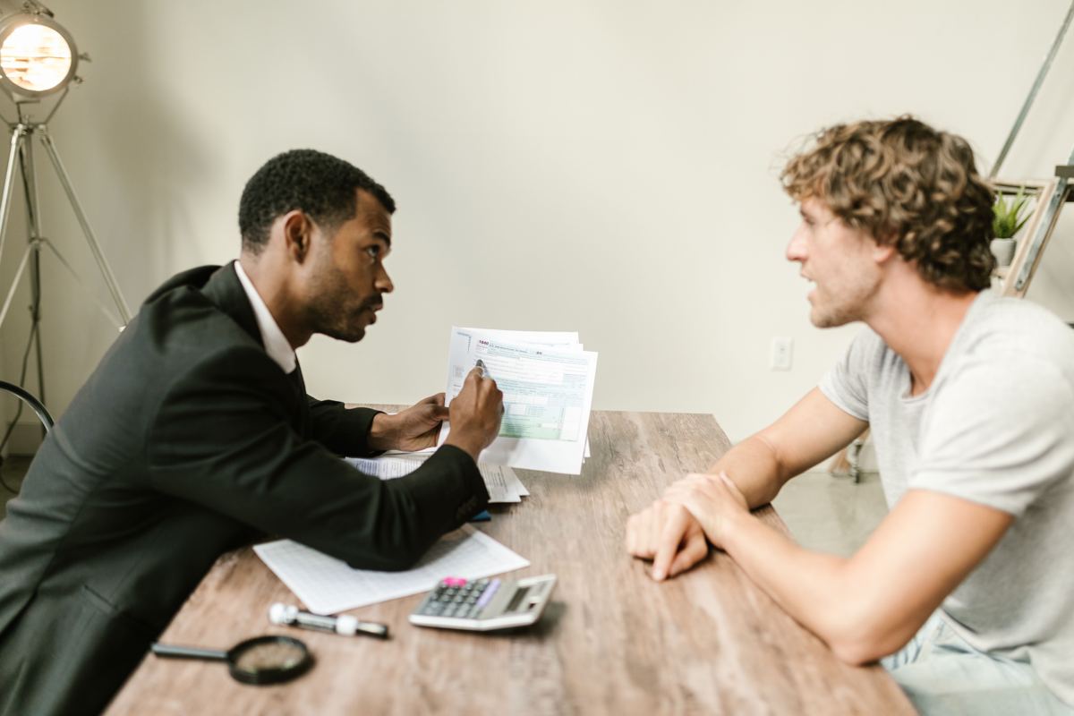 A case manager going over paperwork with a client at a table