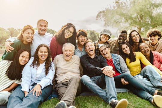 A diverse group of adults of different ages smiling together outdoors